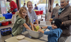 Frau mit Kindern beim Verarbeiten von Kabis zu Sauerkraut.