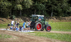 Kinder beim Ackersurfen mit dem Traktor.